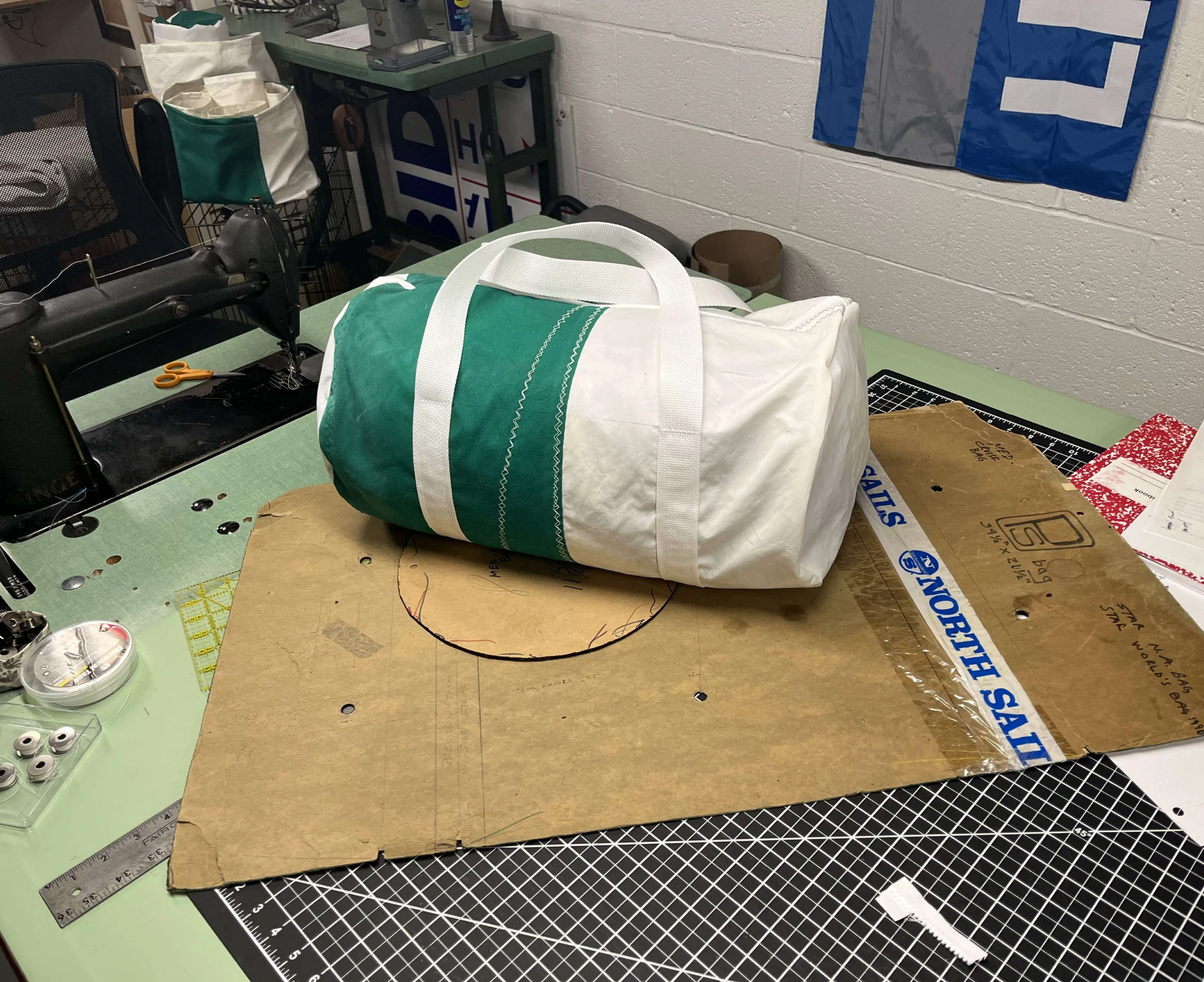 Green and white duffel bag on table