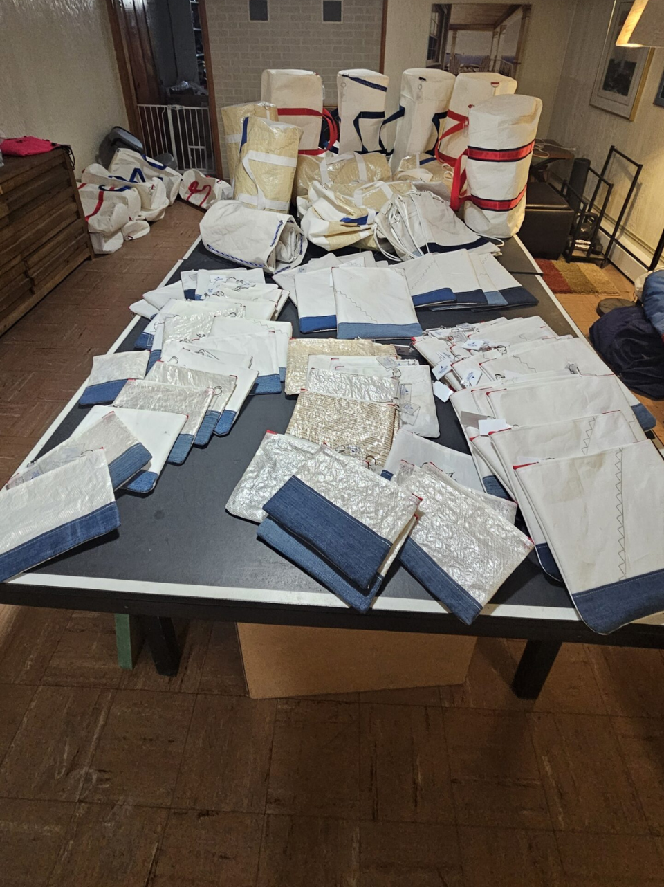 A table covered with various sewing projects and fabric pieces in a cluttered room.